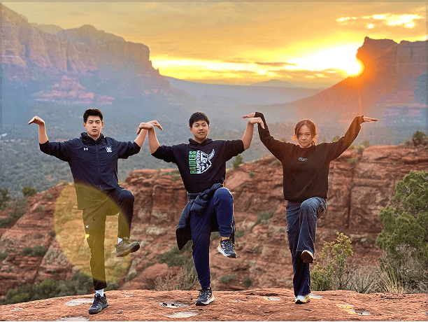 Friends on a rocky outcrop at sunset