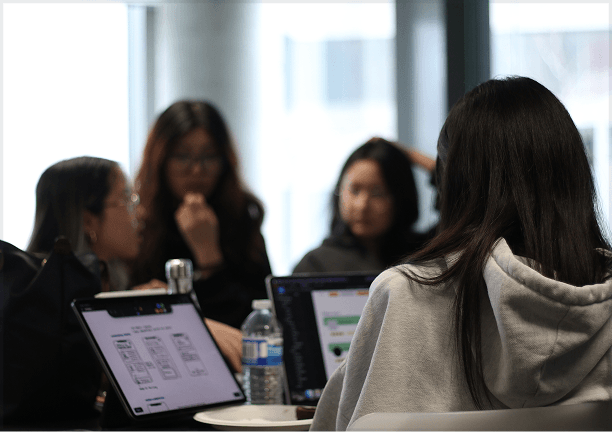 People collaborating with laptops around a table